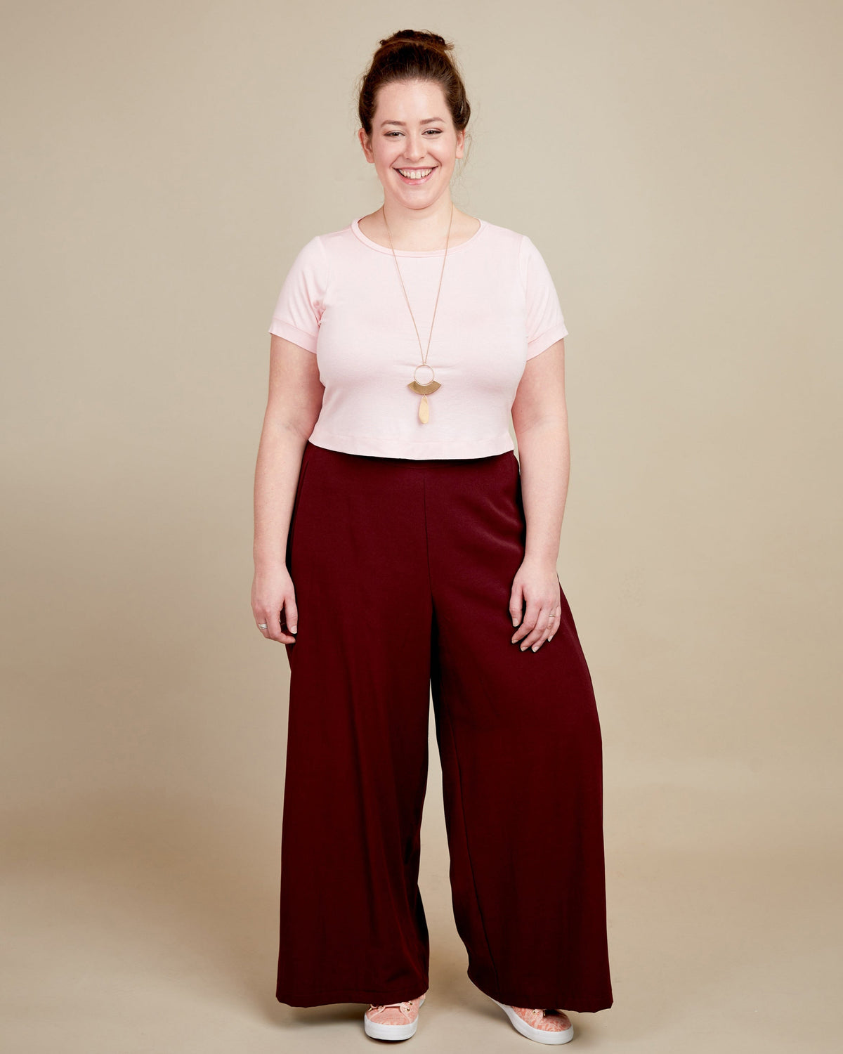 Cashmerette Concord T-Shirt PDF sewing pattern, woman wearing a pink top and burgundy wide-leg pants