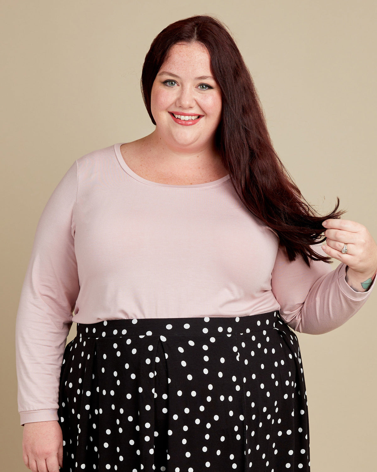 Cashmerette Concord T-Shirt PDF sewing pattern, woman wearing a light pink top and black polka dot pants