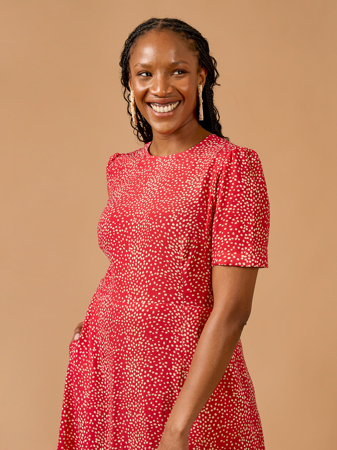 Deer & Doe Eleanor Dress sewing pattern, model in a red dress smiling