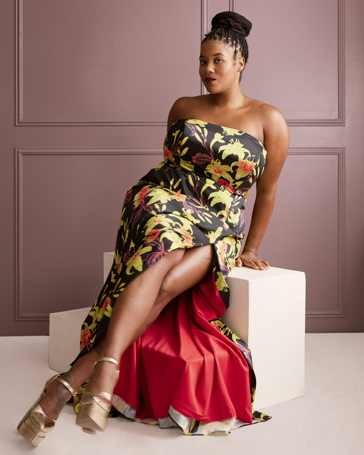 Cashmerette Ellington Dress PDF sewing pattern, woman in a floral strapless dress sitting on a white cube against a purple wall