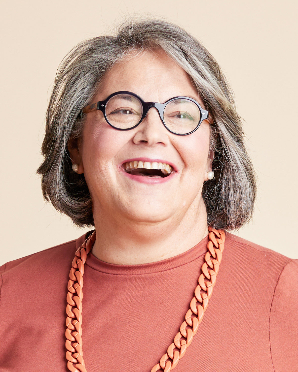 Cashmerette Grafton Dress, Top and Skirt PDF sewing pattern, person with gray hair wearing glasses and a brown shirt with a large orange necklace