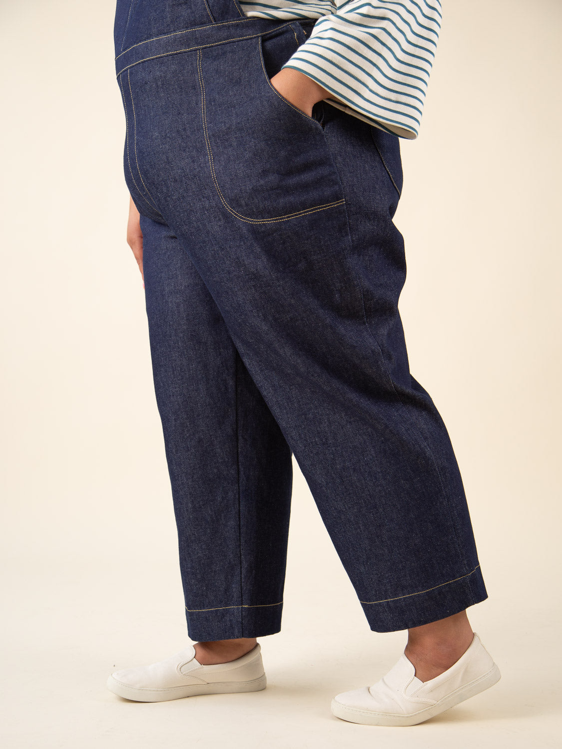 Side view of navy denim overalls made with the Closet Core Jenny Overalls and trousers PDF sewing pattern