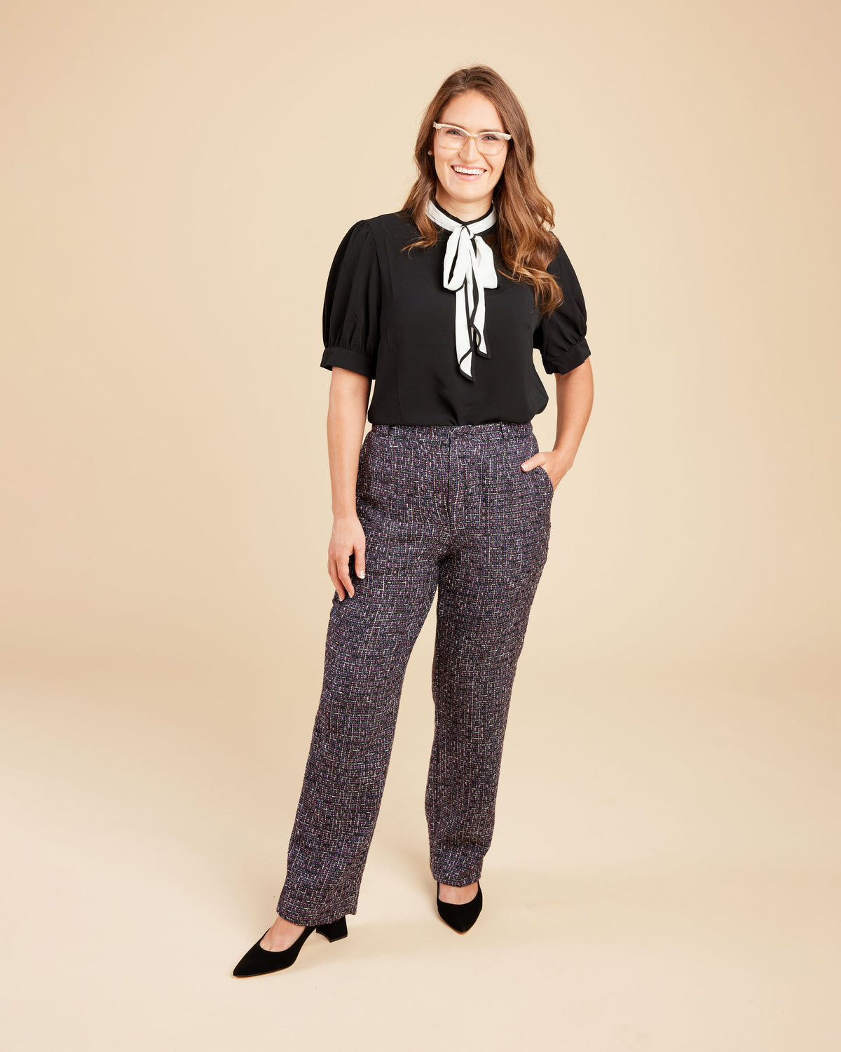 Cashmerette Meriam Trousers PDF sewing pattern, woman wearing a black blouse with a white bow and patterned pants