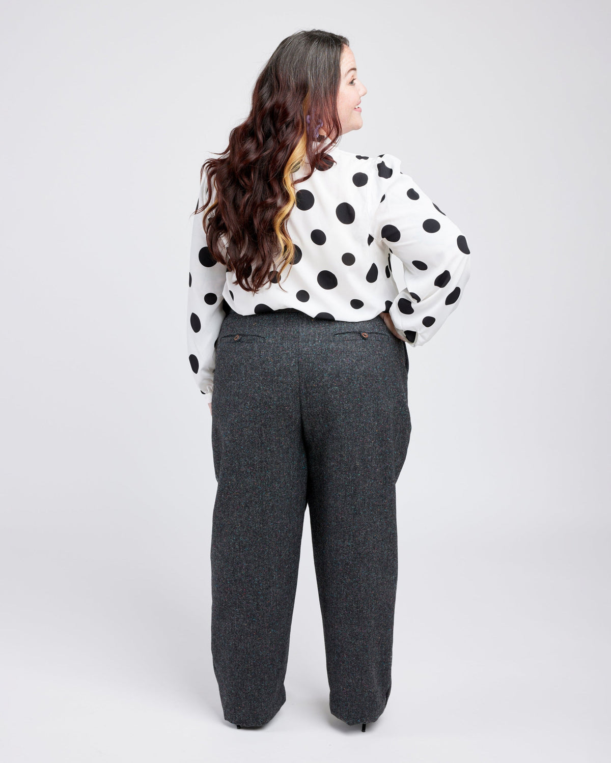 Cashmerette Meriam Trousers PDF sewing pattern, person wearing a polka dot blouse and gray pants, back view