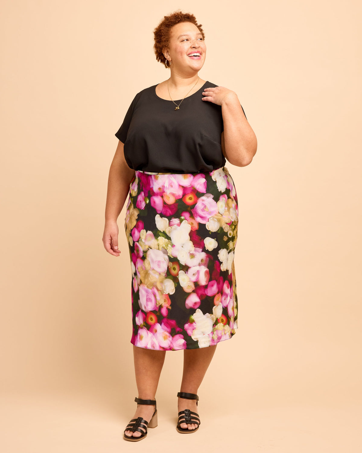 Cashmerette Montrose Top PDF sewing pattern, woman wearing a black top and floral skirt, back view