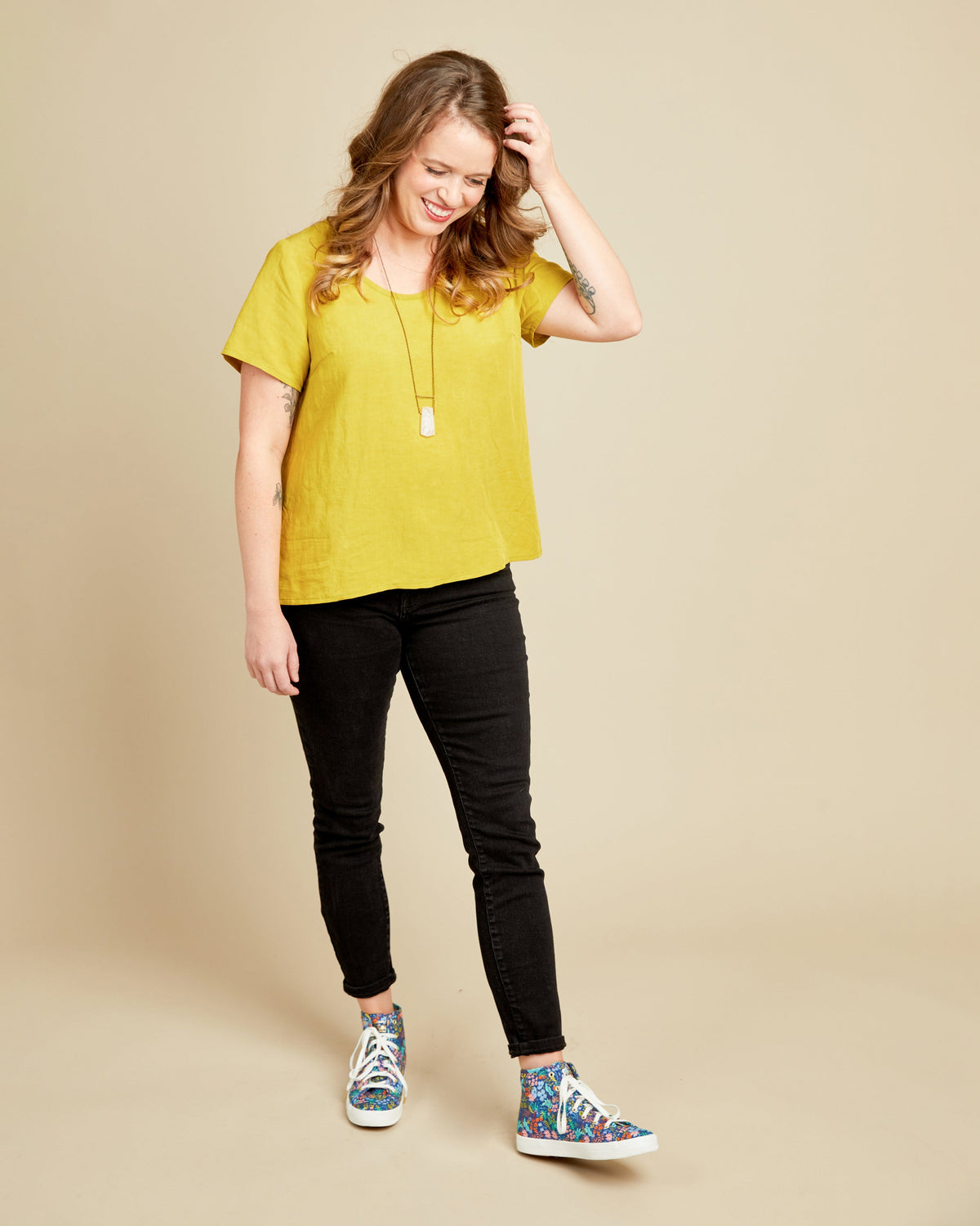 Cashmerette Montrose Top PDF sewing pattern, woman wearing a yellow top and black pants with colorful shoes