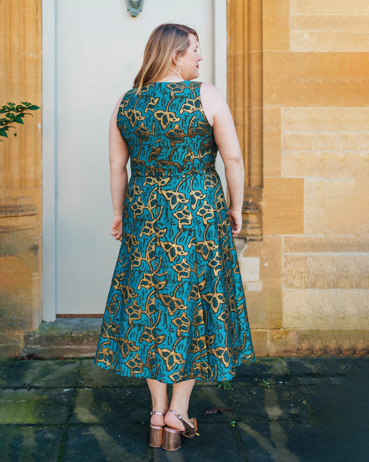 Cashmerette Upton Dress and Skirt Plus expansion pack PDF sewing pattern, woman wearing a blue and gold patterned dress standing in front of a stone