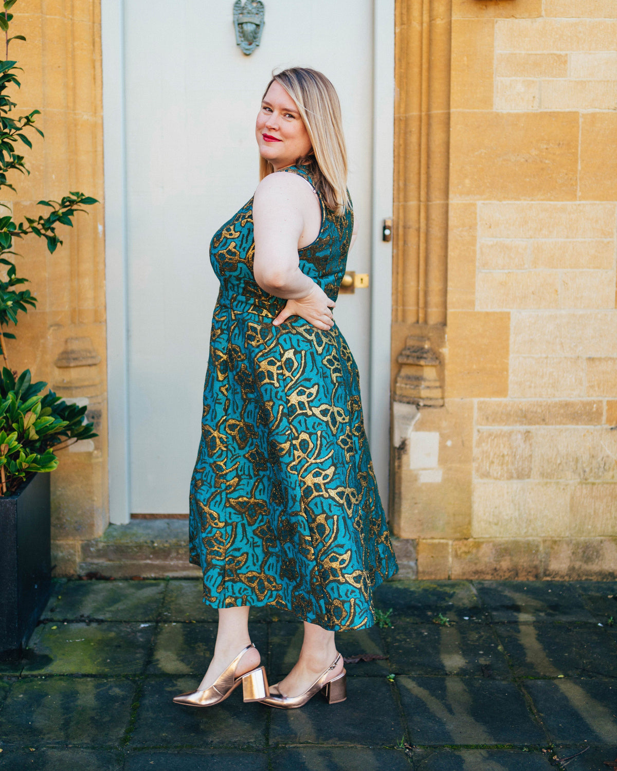 Cashmerette Upton Dress and Skirt Plus expansion pack PDF sewing pattern, woman in a teal patterned dress standing in front of a door.. This dress is