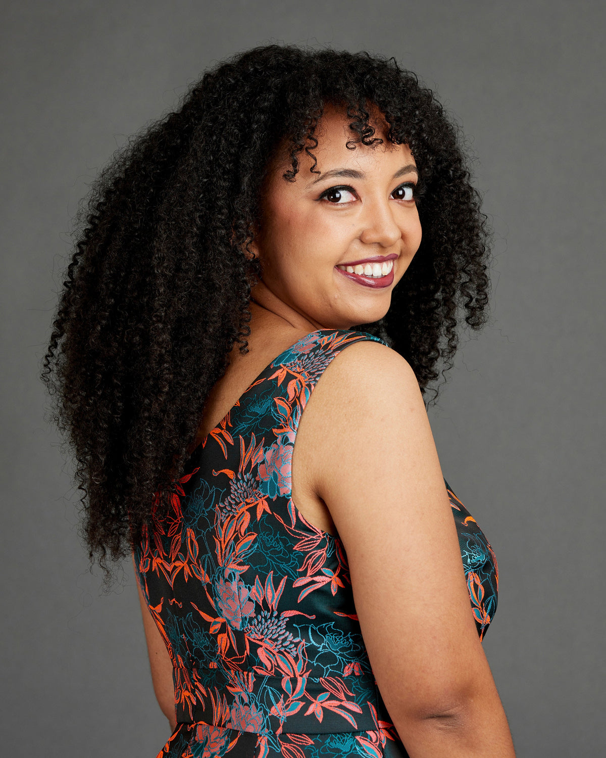 Cashmerette Upton Dress and Skirt Plus expansion pack PDF sewing pattern, woman with curly hair wearing a floral dress
