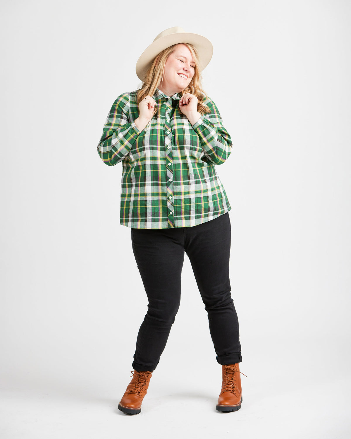 Cashmerette Vernon Shirt PDF sewing pattern, woman wearing a green plaid shirt, black pants, and brown boots
