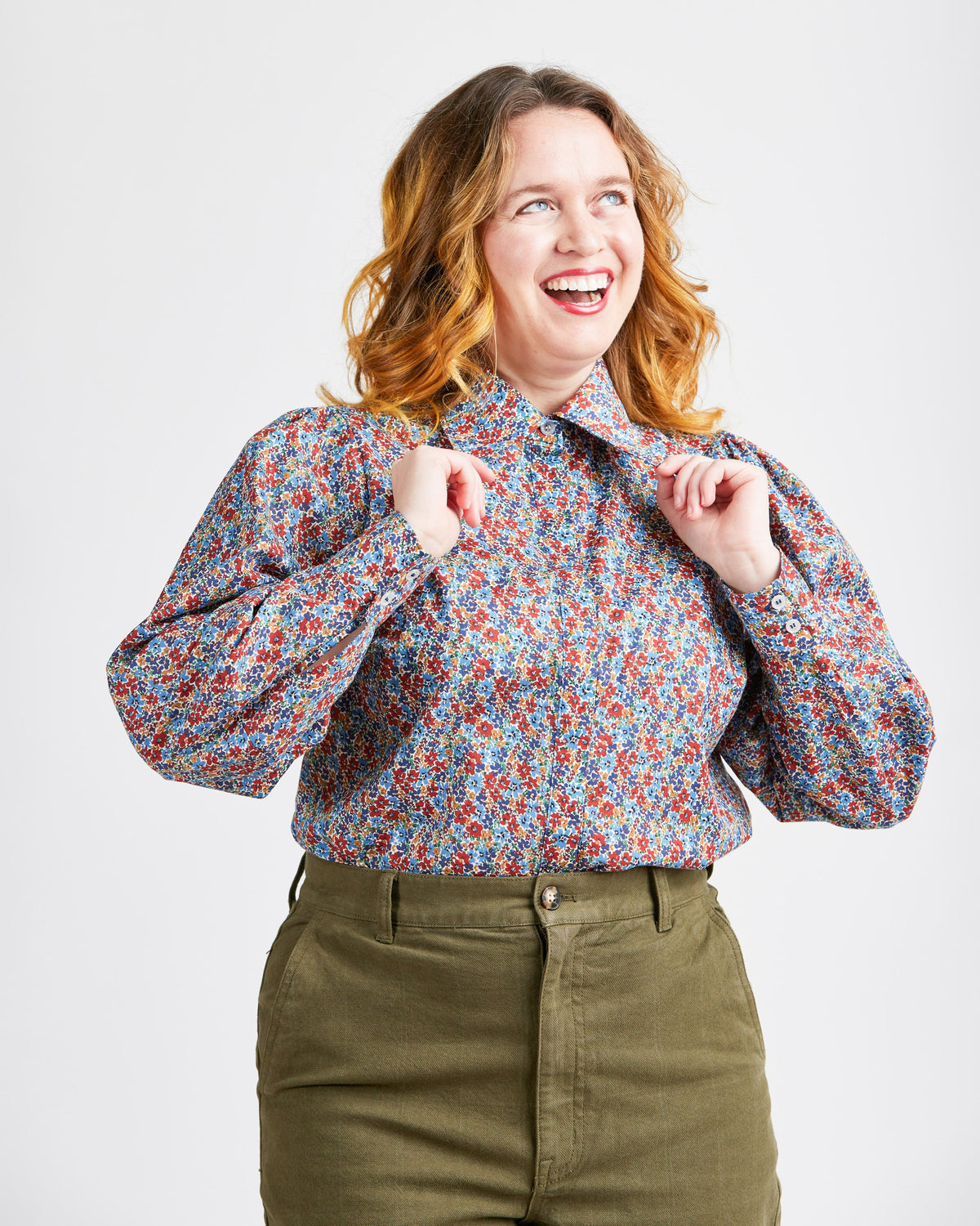 Cashmerette Vernon Shirt PDF sewing pattern, woman wearing a floral blouse and green pants, seated