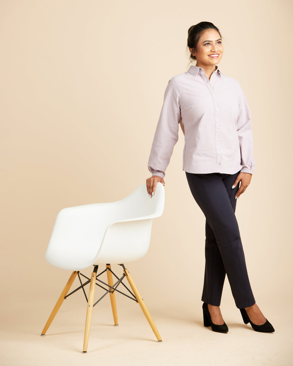 Cashmerette Vernon Shirt PDF sewing pattern, woman in a light purple shirt and dark pants standing next to a white chair