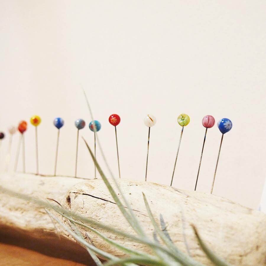 Cohana Tombo-dama glass sewing pins, pinned along a fabric edge